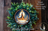 A wreath with a Christmas scene featuring a church and a snowy landscape, surrounded by greenery.