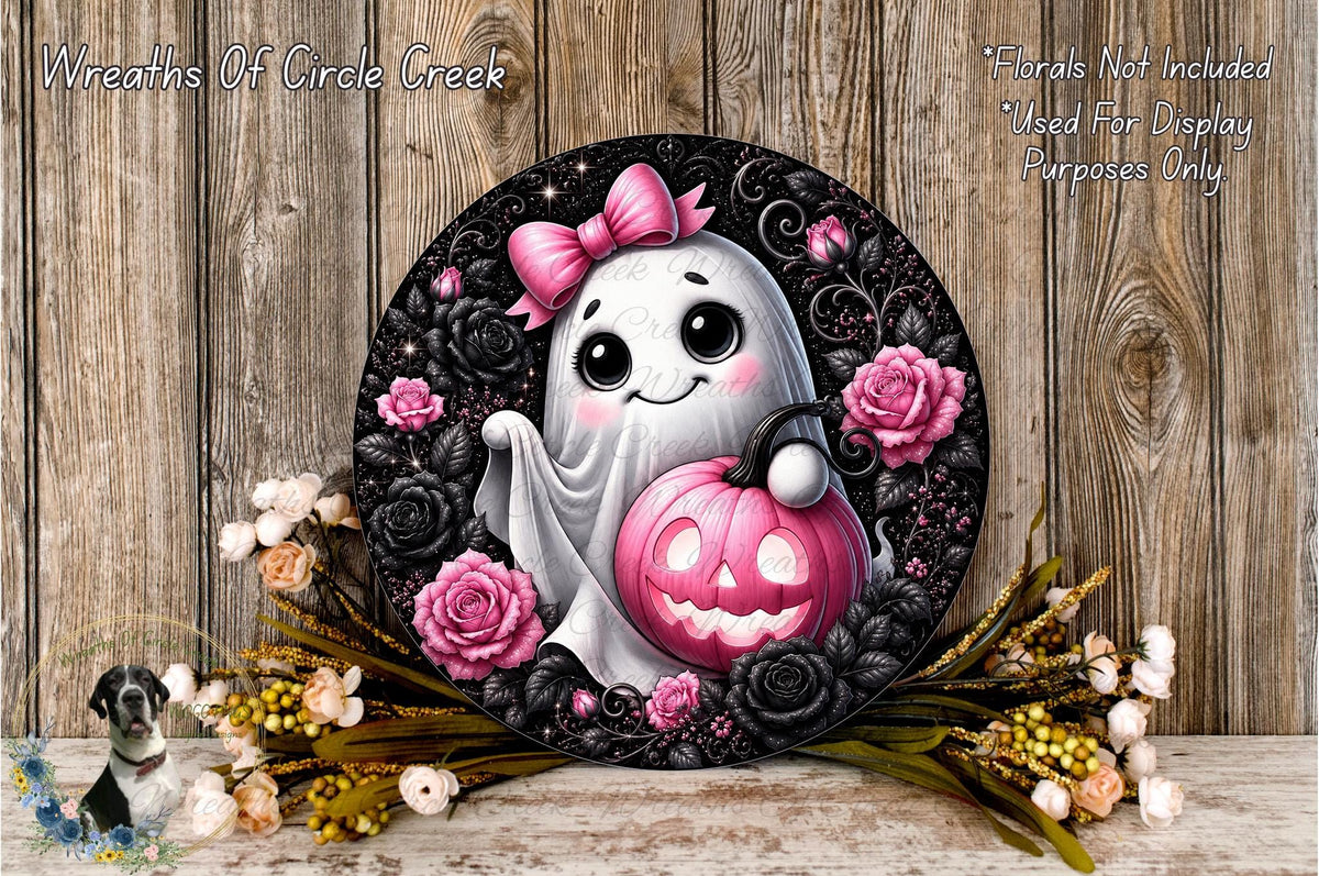 A Halloween-themed wreath featuring a ghost with a pink bow and a carved pumpkin, surrounded by black and pink flowers, against a wooden background.