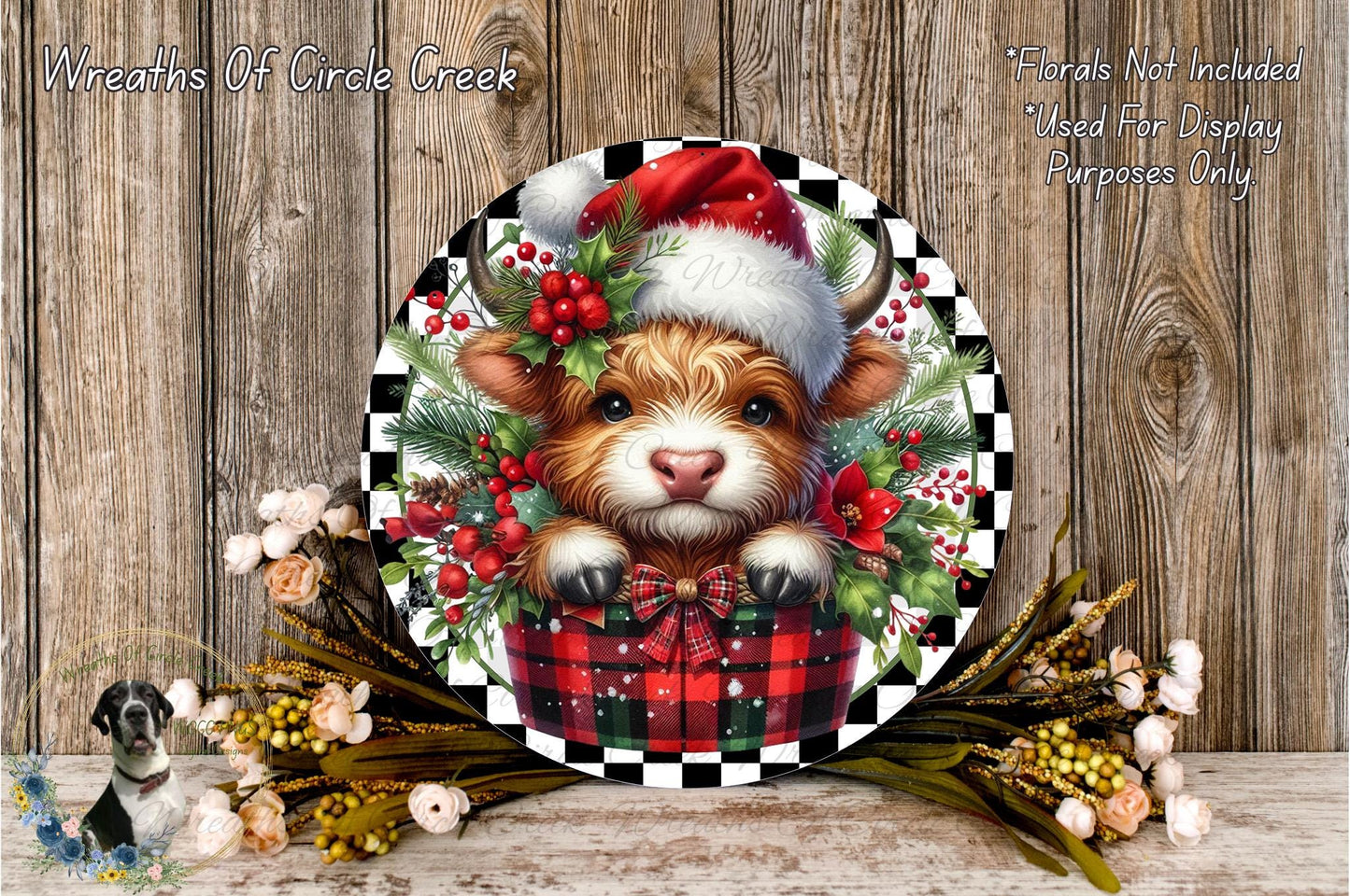 A decorative plate featuring a cow wearing a Santa hat, surrounded by a festive arrangement of flowers and greenery, placed on a wooden surface.