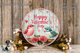 a round wooden sign with a floral design, surrounded by a wreath of flowers and a bird illustration. The sign displays the text "Happy Valentine's Day" and includes a bird illustration.