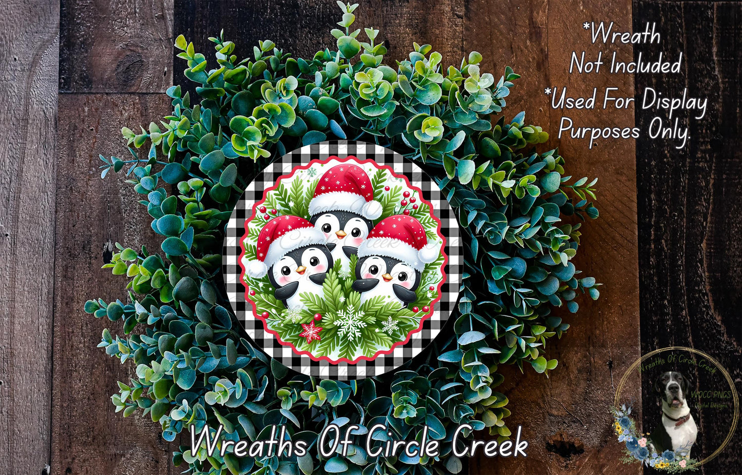 A wreath made of green foliage and featuring three penguins wearing Santa hats.