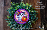 A wreath made of green leaves and a purple circle with a cartoon ghost holding a lollipop and a pumpkin.