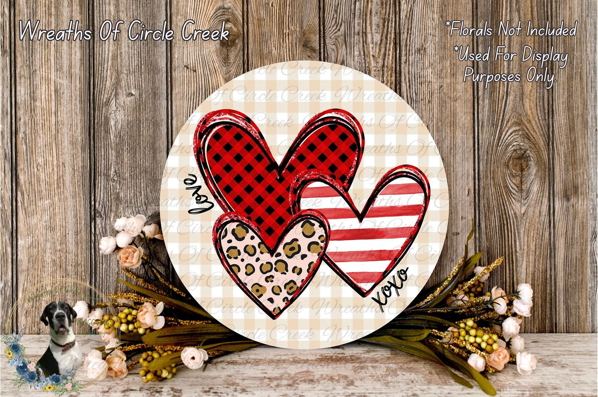 a round wooden plaque with a heart design, surrounded by flowers and foliage.