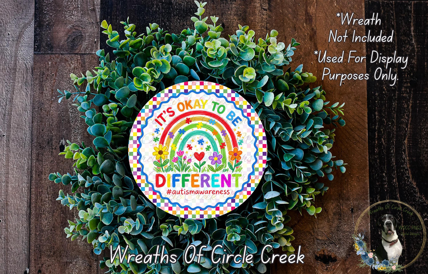 A wreath made of green leaves and flowers, with a colorful sign that reads "It's OKAY TO BE DIFFERENT #autismawareness" in the center.
