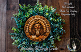 A wreath made of green leaves and a turkey decoration, with a wooden background.