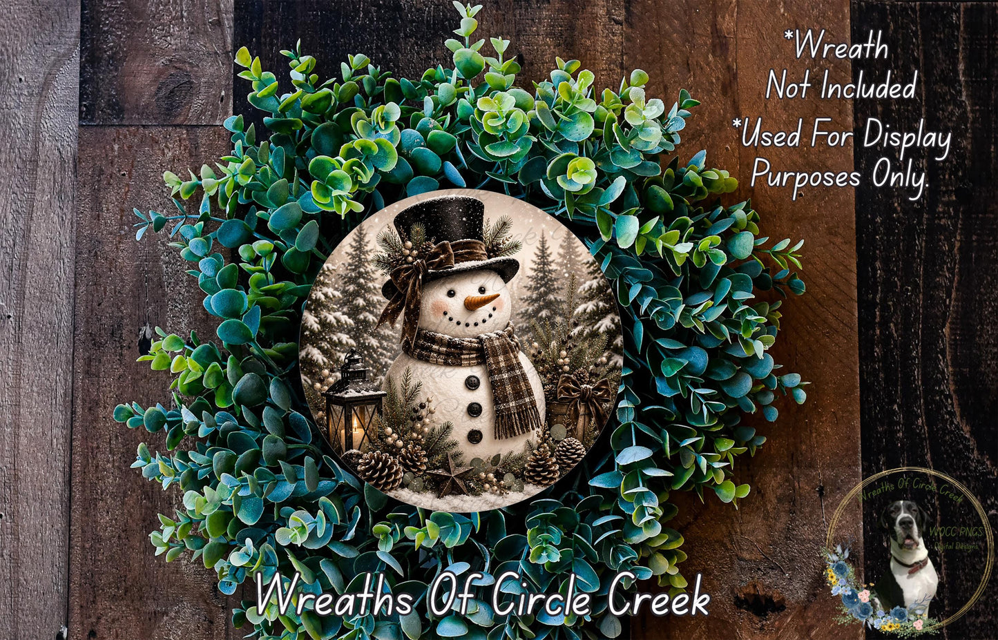 A wreath featuring a snowman surrounded by evergreen branches and pine cones, with a text overlay that reads "Wreath Not Included * Used For Display Purposes Only" and "Wreaths of Circle Creek".