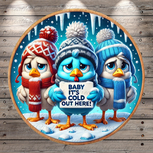 A group of three cartoon birds wearing winter hats and scarves, standing on a snowy surface and holding a sign that says "Baby it's cold here!".
