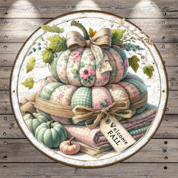 A decorative arrangement of pumpkins and blankets, with a "Welcome Fall" sign, set against a rustic wooden background.