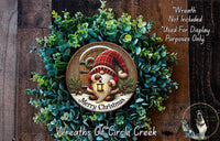 A wreath with a gnome and a lantern, surrounded by greenery, with a message that reads "Merry Christmas" and "Wreaths of Circle Creek".