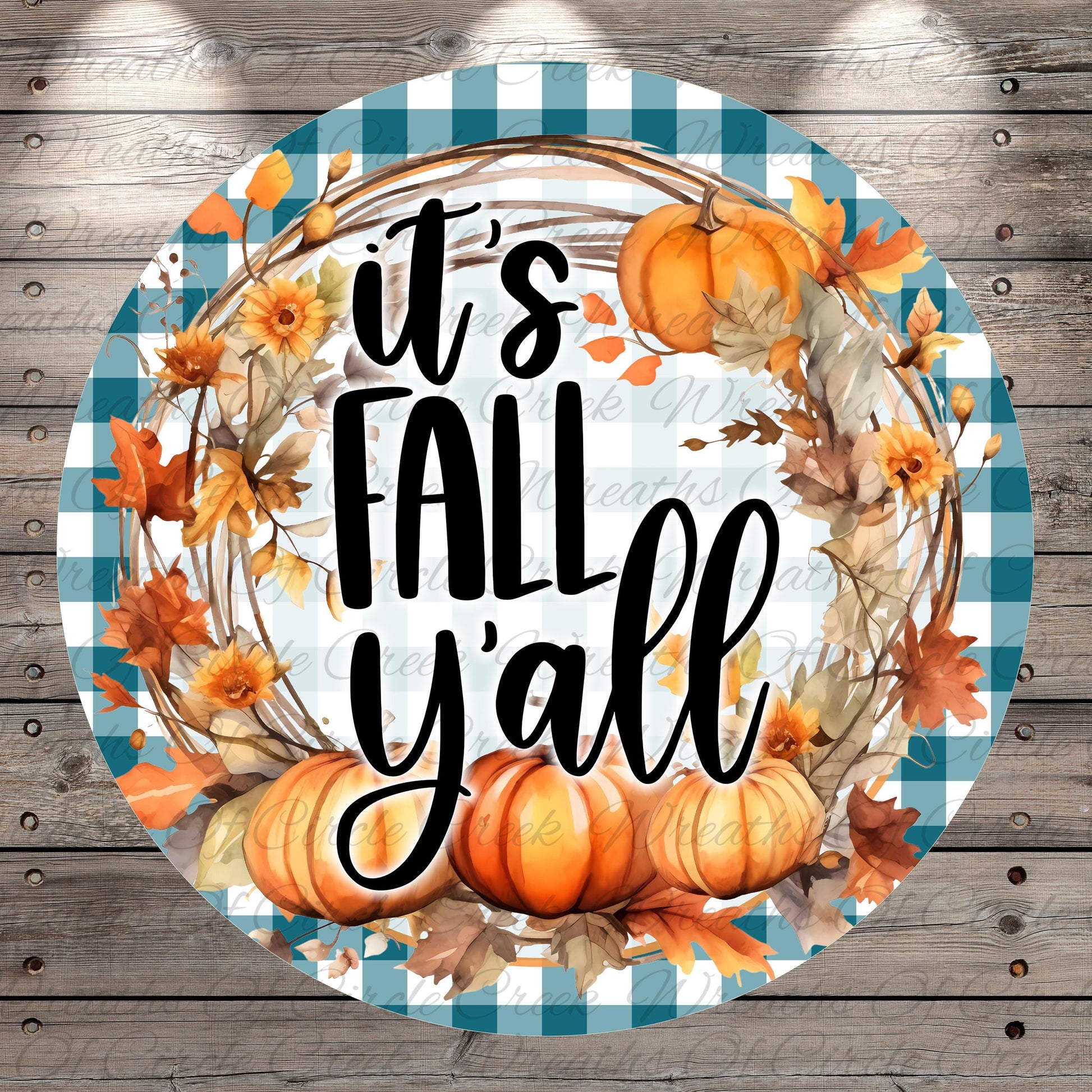 A circular design with a checkered border and a wreath made of autumn leaves, pumpkins, and flowers. The text "It's FALL Y'ALL" is displayed in a stylized font.