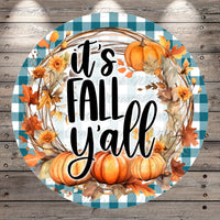 A circular design with a checkered border and a wreath made of autumn leaves, pumpkins, and flowers. The text "It's FALL Y'ALL" is displayed in a stylized font.