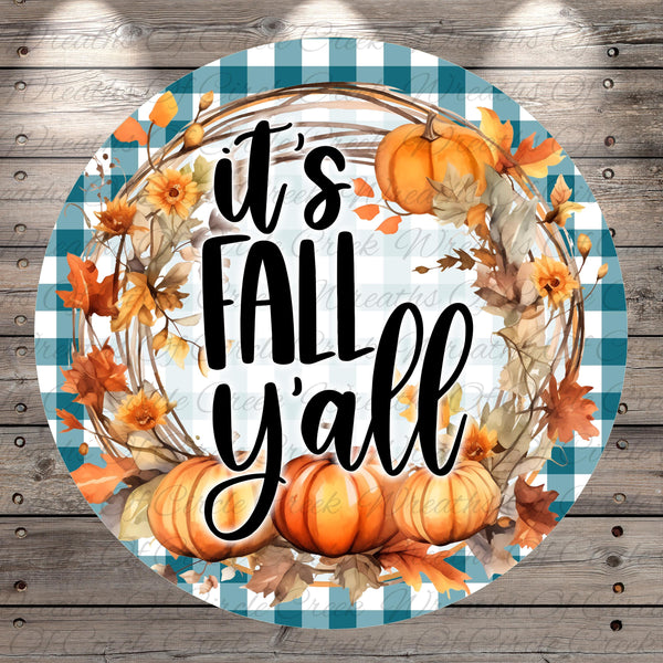 A circular design with a checkered border and a wreath made of autumn leaves, pumpkins, and flowers. The text "It's FALL Y'ALL" is displayed in a stylized font.