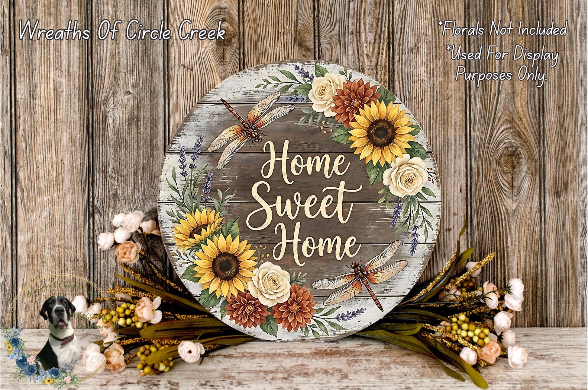 A rustic wooden sign with the text "Home Sweet Home" surrounded by a wreath of sunflowers and other flowers, placed on a wooden surface.
