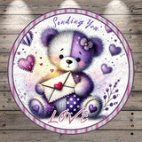 A teddy bear holding an envelope with a heart on it, surrounded by hearts and flowers, with the text "Sending You" and "Love" written around the image.
