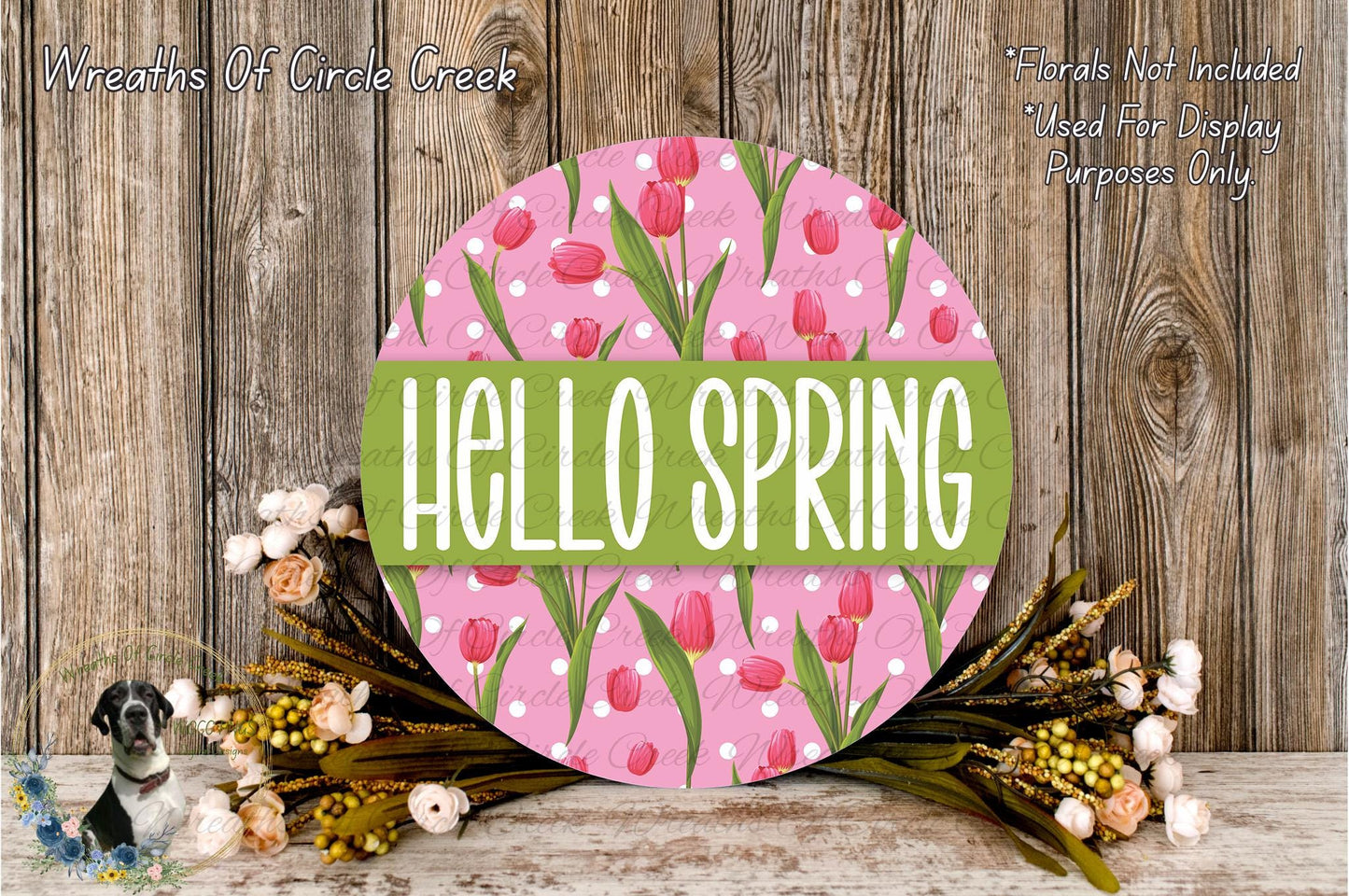 a circular sign with the text "Hello Spring" in a pink and green floral design, surrounded by a wreath of flowers and greenery.