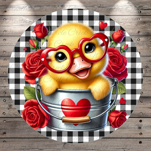 A cheerful yellow duck wearing red glasses and holding a bucket with a red heart on it, surrounded by red roses.