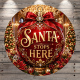 A large, ornate Christmas ornament with the text "Santa stops here" in a decorative font, surrounded by other holiday decorations such as poinsettias, ornaments, and a Christmas tree.