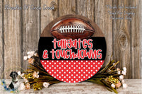 a decorative sign with a football and the words "tailgates & touchdowns" written on it, placed on a wooden surface.