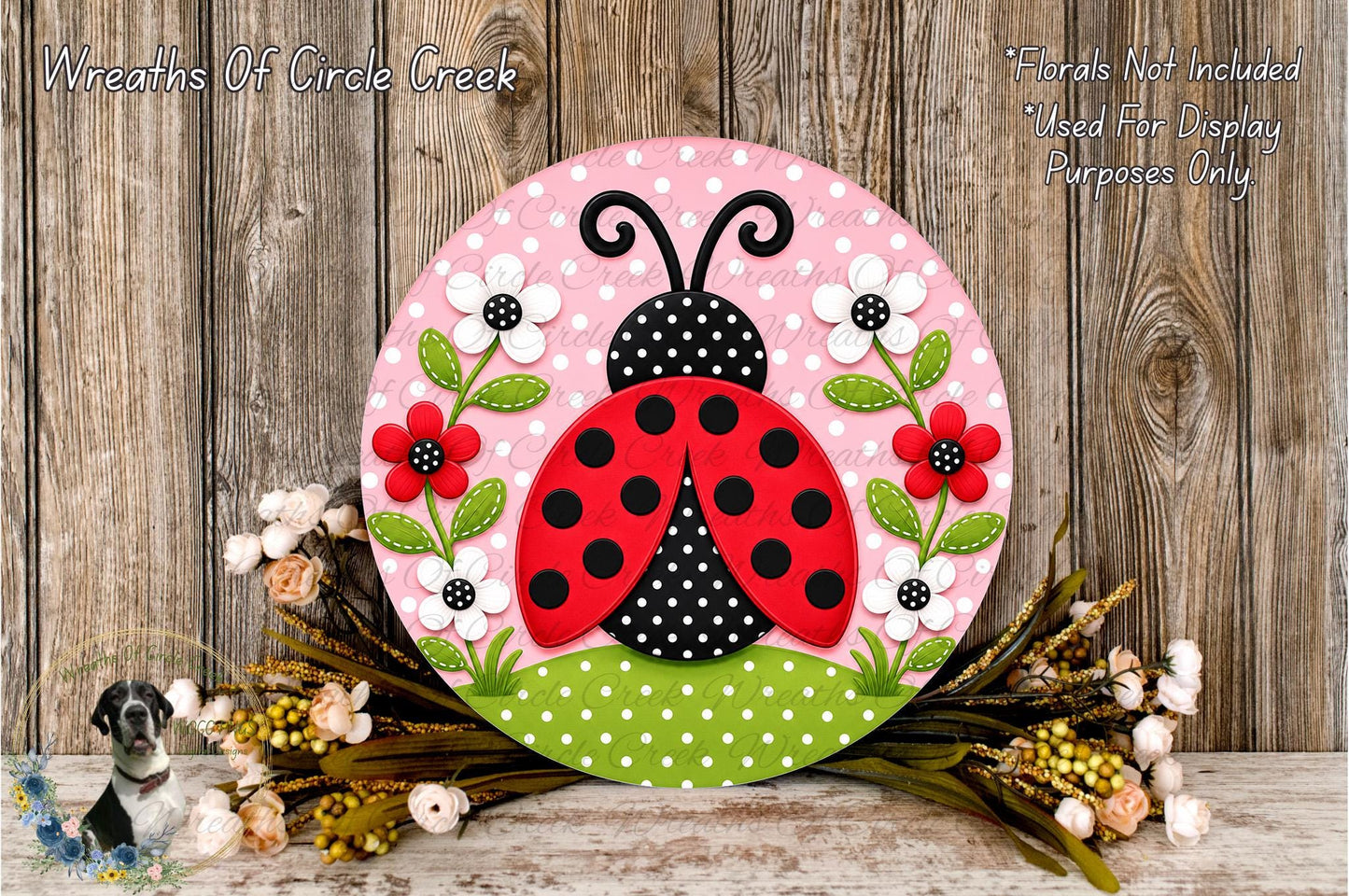 A decorative round sign featuring a red ladybug surrounded by flowers and green leaves, placed on a wooden surface.