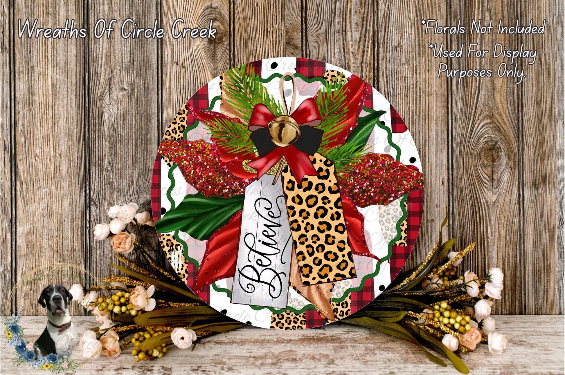 A decorative wreath with a leopard print design, red and green accents, and a red bow. The wreath is surrounded by flowers and placed on a wooden surface.
