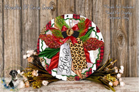 A decorative wreath with a leopard print design, red and green accents, and a red bow. The wreath is surrounded by flowers and placed on a wooden surface.