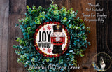 a wreath with a nutcracker figure and the text "Joy to the World" on it, surrounded by greenery.
