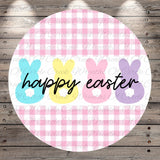 A circular design with a pink and white checkered pattern, featuring three bunny-shaped illustrations in different colors - blue, yellow, and pink. The text "happy easter" is written in black below the bunny illustrations.