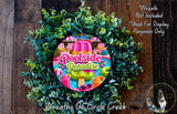A wreath made of green leaves and colorful illustrations of a poolside, with the text "Poolside Paradise" prominently displayed.