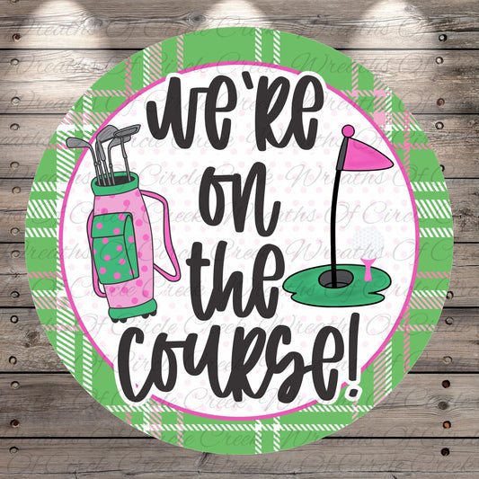 A circular sign with the text "we're on the course!" written on it, surrounded by golf-related elements such as a golf bag, clubs, and a golf ball.