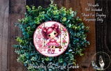 A wreath made of green leaves and flowers, featuring a small cartoon girl with pink hair and a pink dress. The wreath is displayed on a wooden surface, and there is a text overlay that reads "Wreath Not Included * Used For Display Purposes Only".