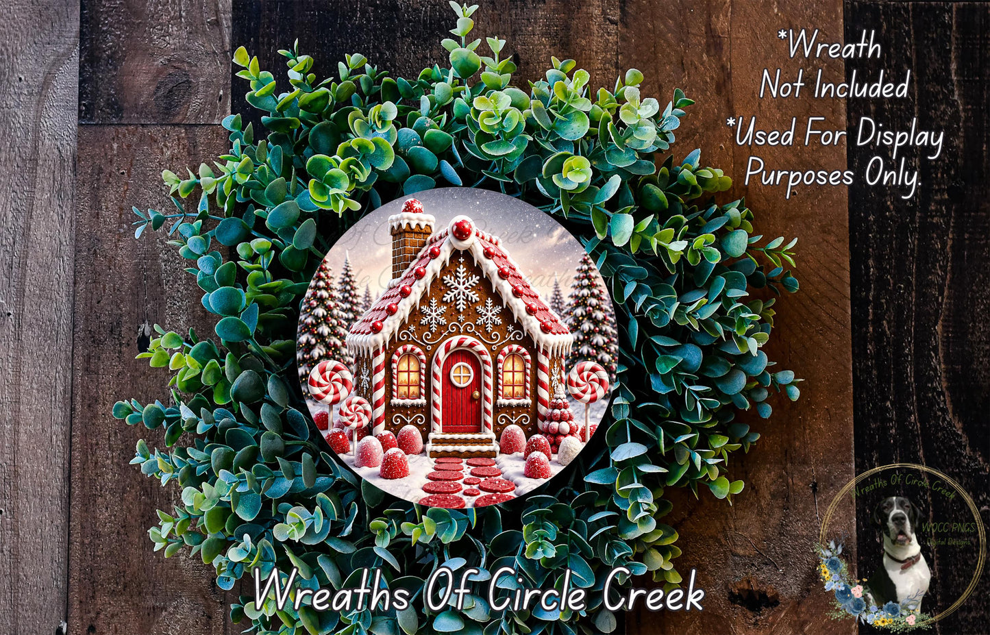 A wreath featuring a gingerbread house surrounded by greenery, with a caption stating that the wreath is not included in a display and is used for purposes only.