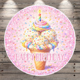A round, pink-colored birthday cake with a candle and sprinkles, surrounded by the text "Happy Birthday" in a playful font.