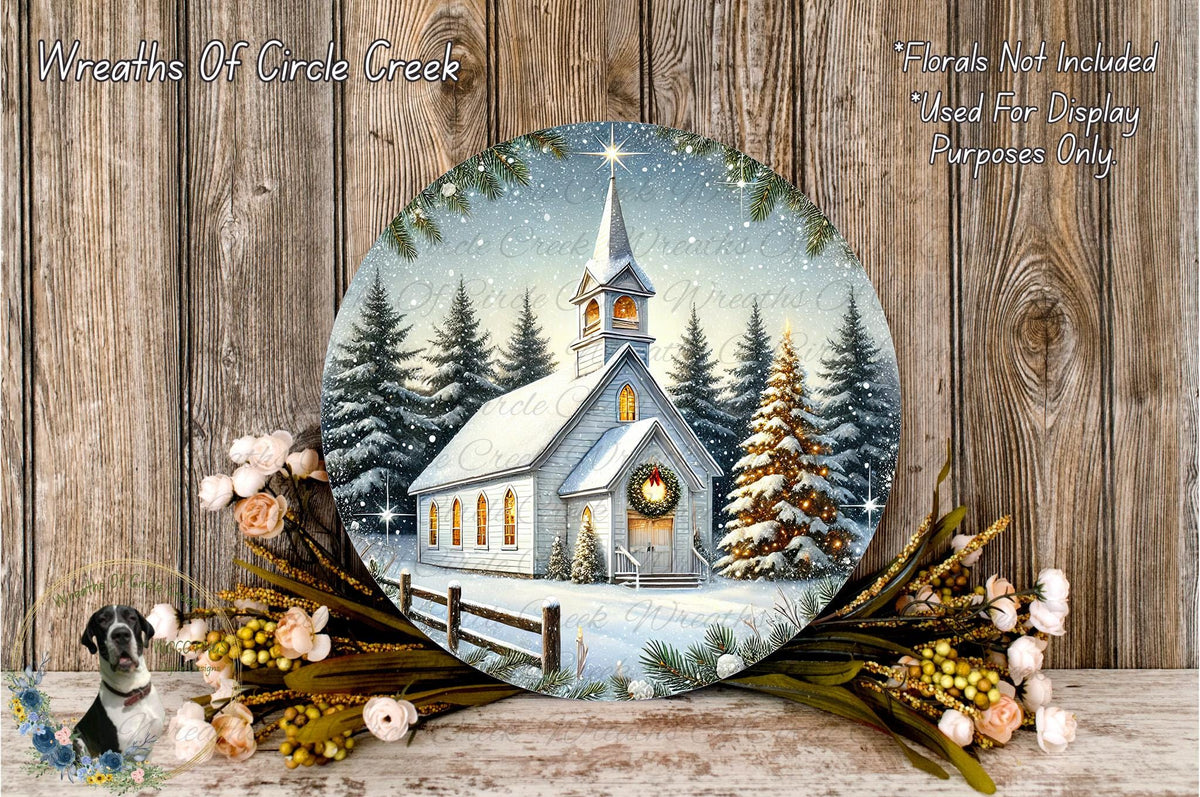A round wooden plaque depicting a snowy church surrounded by pine trees and a wreath, with a starry night sky in the background.
