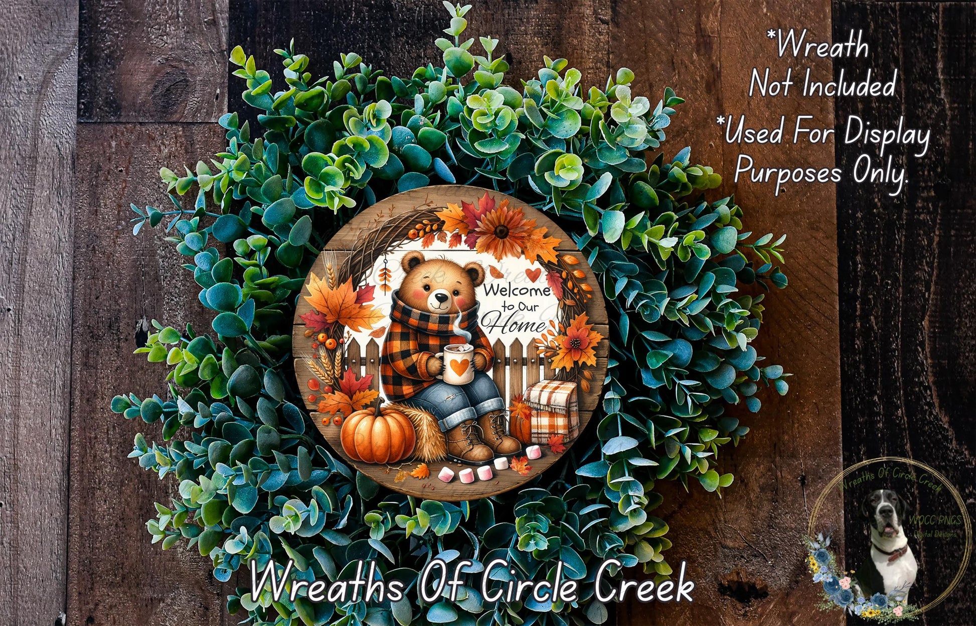 A wreath made of green leaves and a teddy bear, with a sign that says "Welcome to our Home" and a dog in the background.