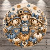 A round, decorative image featuring three scarecrow dolls surrounded by pumpkins, flowers, and leaves, with a sign that says "Happy Fall Y'all".