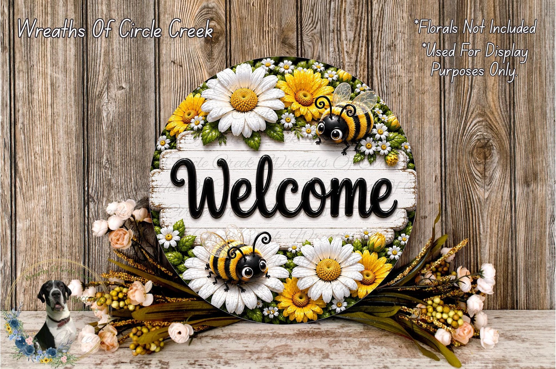 A decorative welcome sign with a floral design, featuring a bee and flowers, placed on a wooden surface.