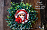 A wreath made of green plants and a red poinsettia flower, featuring a cat wearing a Santa hat.