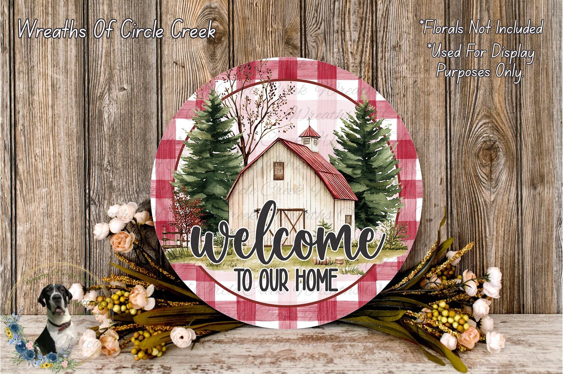 a round wooden sign with a barn and trees, surrounded by flowers and greenery, with the text "Welcome to Our Home" displayed on it.