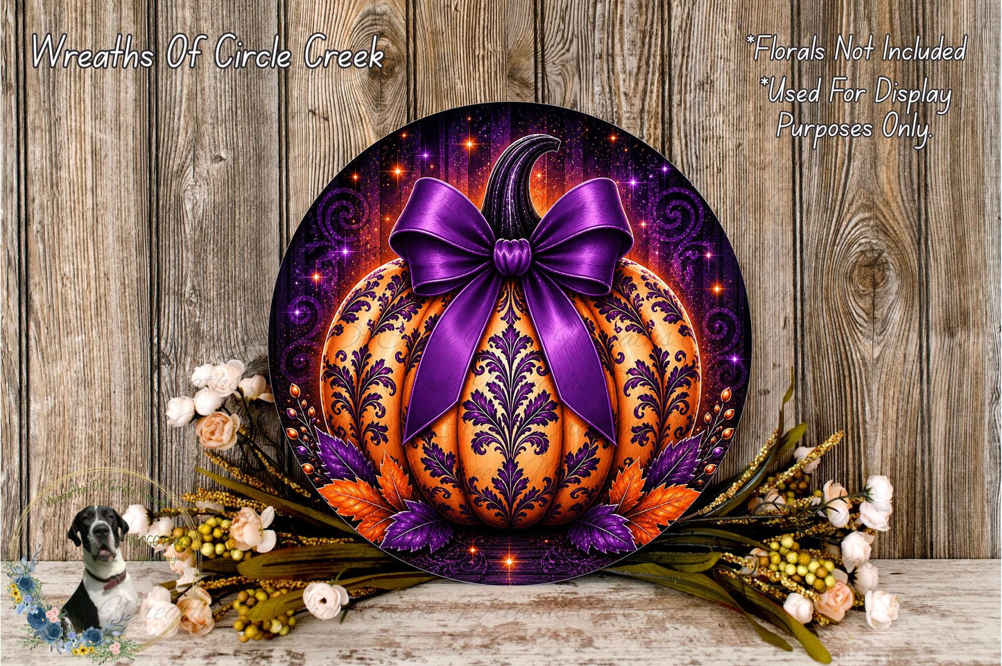 a decorative pumpkin with a purple bow, surrounded by a floral arrangement and placed on a wooden surface.
