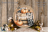 a round wooden sign with the word "Thankful" written on it, surrounded by autumn-themed decorations such as pumpkins, flowers, and a plaid cloth.