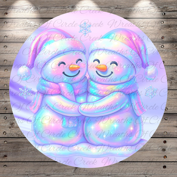 A pair of colorful snowmen embracing each other, with a snowy background and a textured wooden surface.