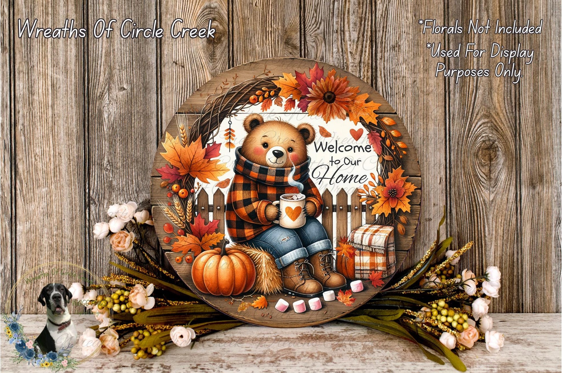 A wooden wreath with a teddy bear, autumn leaves, pumpkins, and flowers, along with the text "Welcome to our Home".