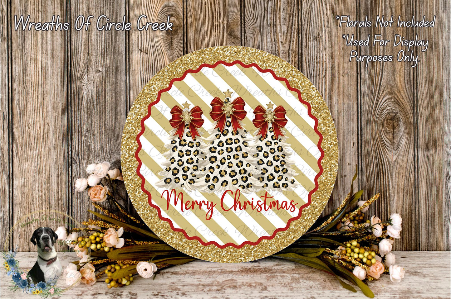 A festive Christmas wreath with a glittery gold border and a red ribbon design, surrounded by a floral arrangement and a wooden background.