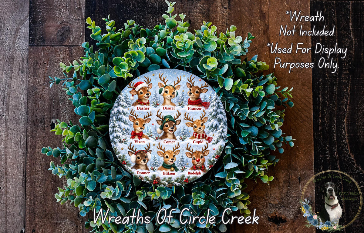A wreath made of green leaves and a circular design featuring a group of deer with names on them, placed on a wooden surface.