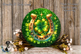 a horseshoe with a four-leaf clover on it, surrounded by a wreath of flowers and a wooden background.