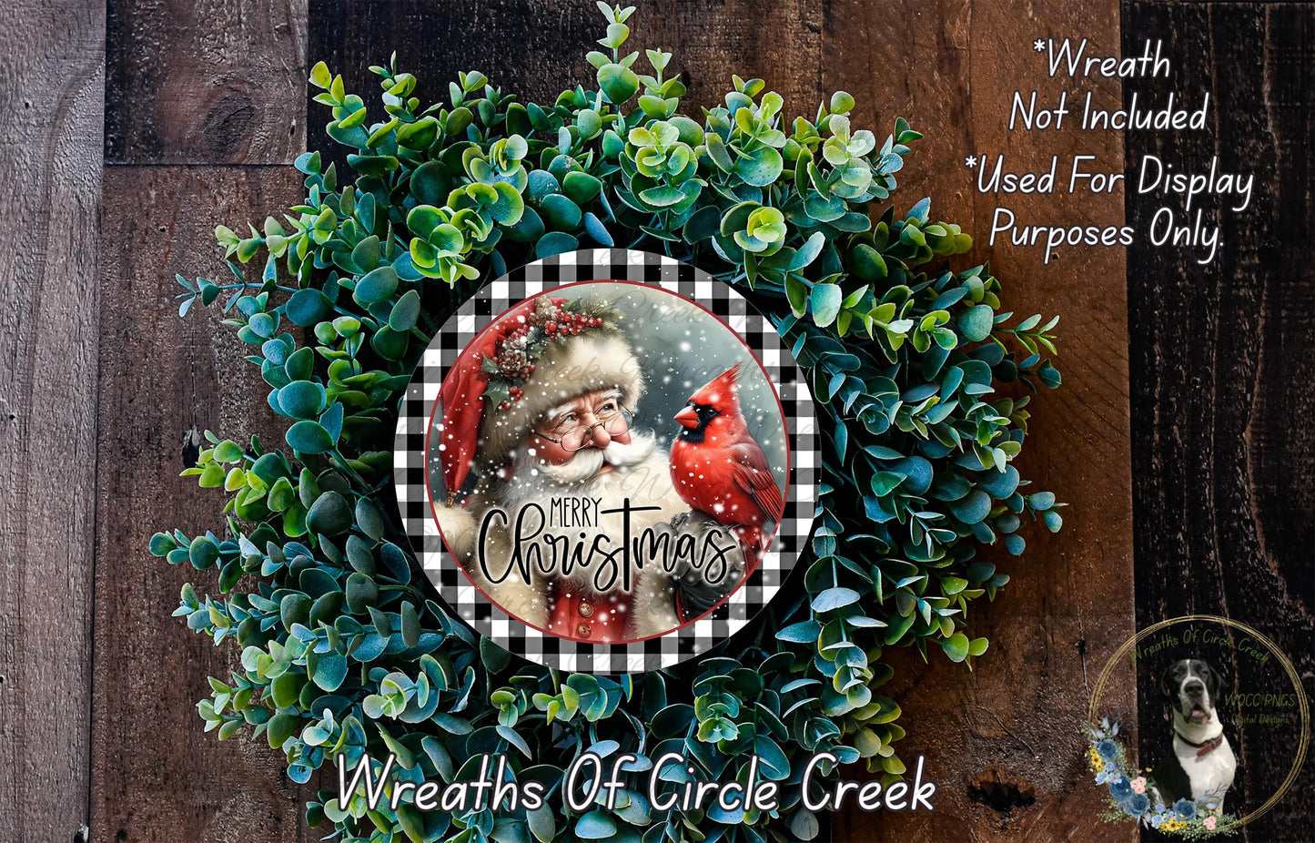 A Christmas wreath made of evergreen branches and a red cardinal bird, with a Santa Claus image in the center. The wreath is displayed on a wooden background, and there is text indicating that the wreath is not included in a display and is used only for purposes.