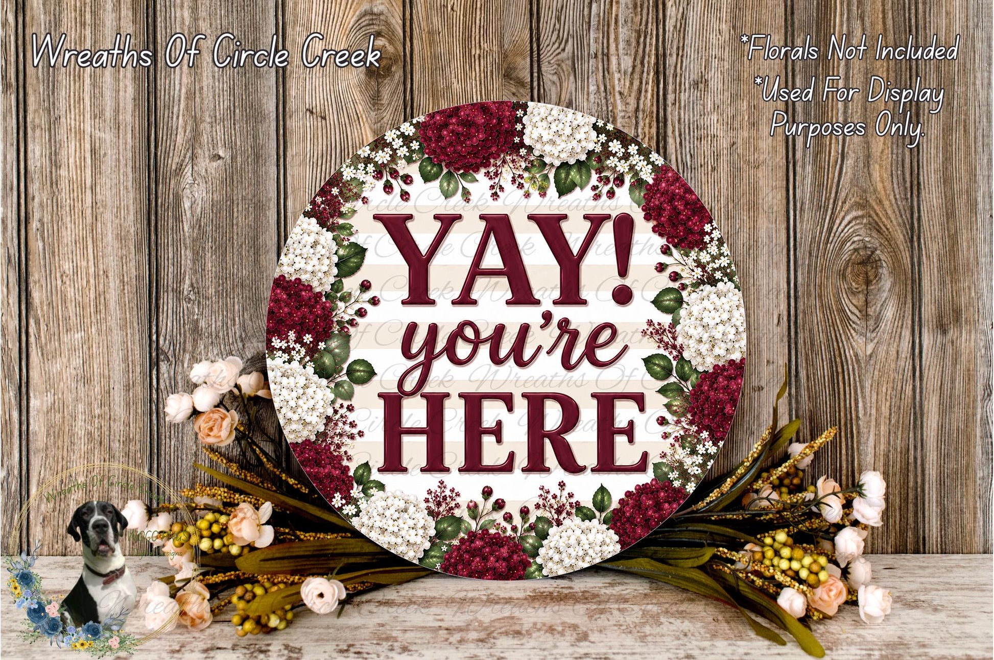 a round wooden sign with the text "YAY! you're here" surrounded by a floral arrangement.