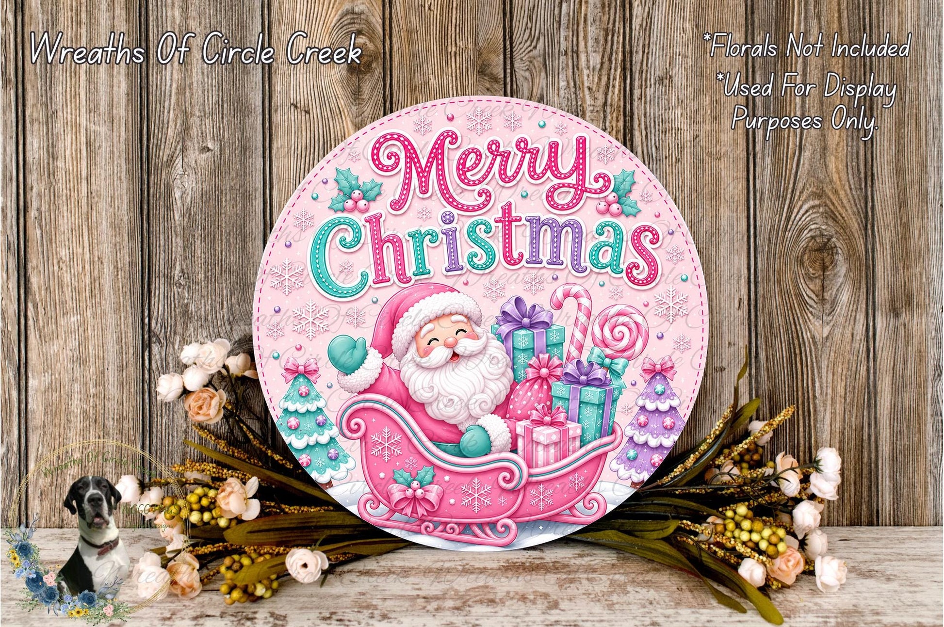 A festive Christmas wreath with a Santa Claus illustration, surrounded by flowers and placed on a wooden surface.