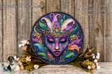 a decorative round plaque with a colorful, intricate face design, surrounded by a variety of flowers and foliage.
