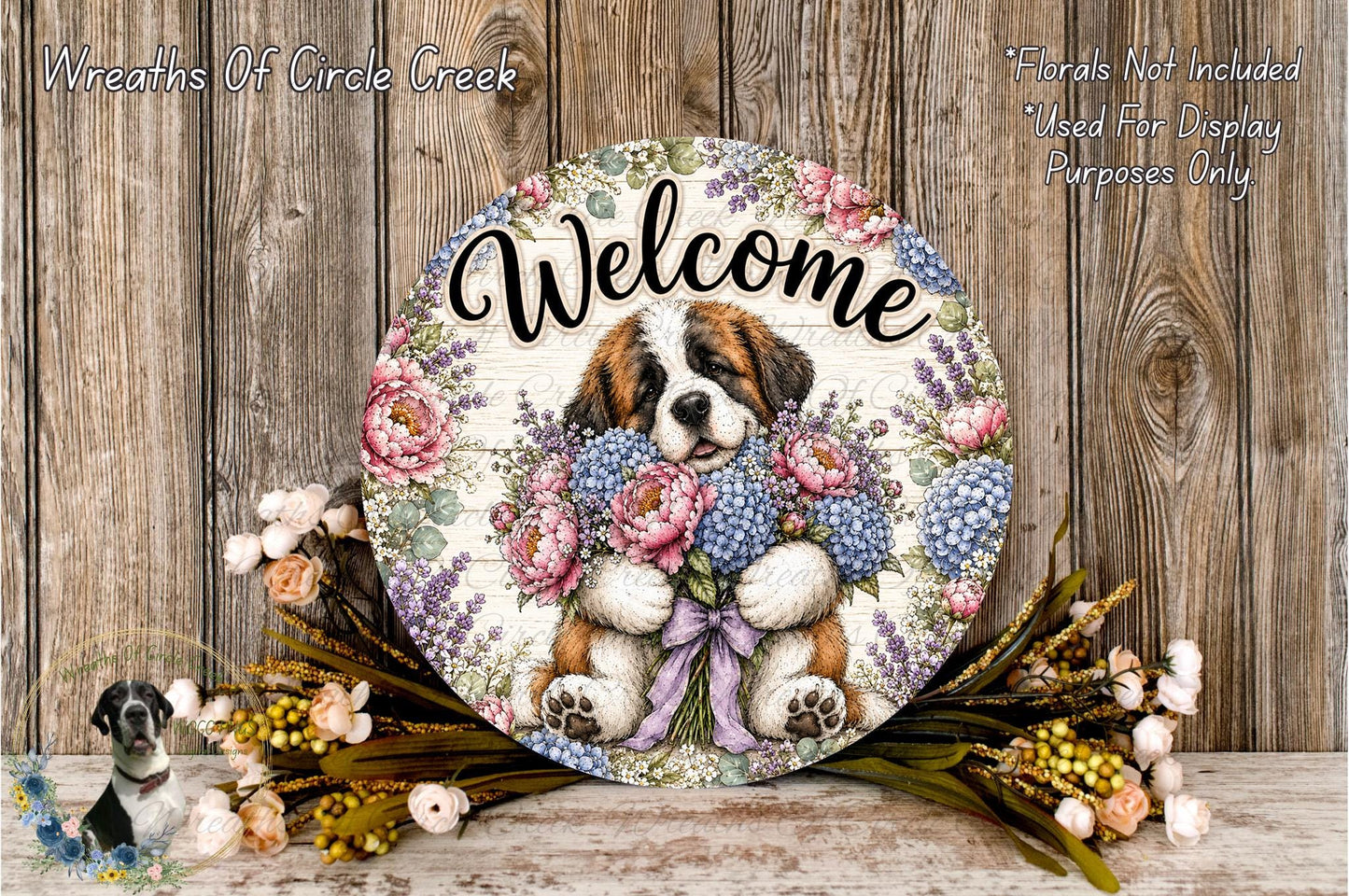 A decorative welcome sign featuring a dog holding a bouquet of flowers, placed on a wooden surface with a floral arrangement and some flowers nearby.